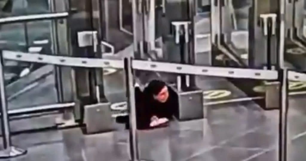 Femeie se târăște pe burtă prin sistemul de securitate al aeroportului pentru a urca, fără bilet, în avion.