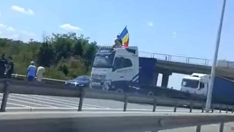 Șofer de TIR blochează A1 și își arată mândria națională fluturând steagul României.
